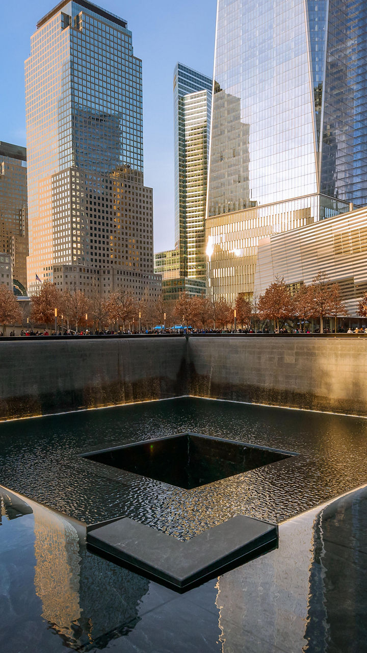 9/11 Memorial with city skyline reflection