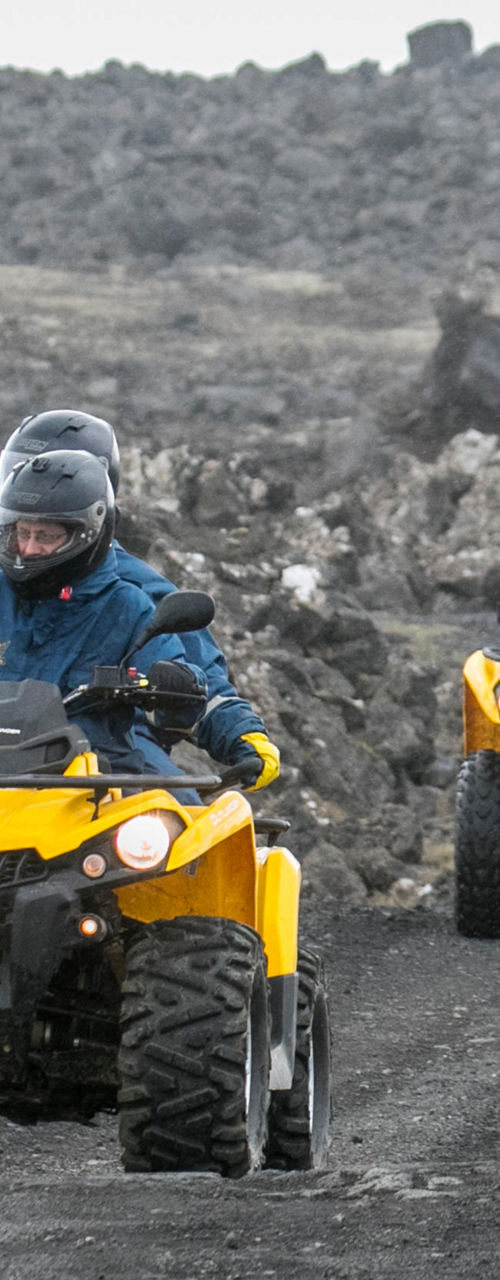 Group riding yellow ATVs on rocky terrain