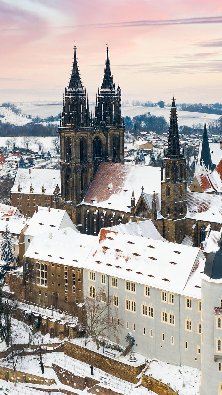 Snowy hilltop castle and town at sunset