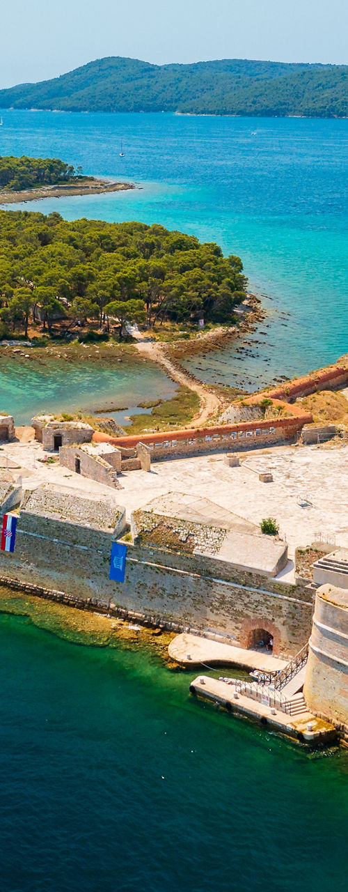 Historic stone fortress on turquoise coastal waters aerial
