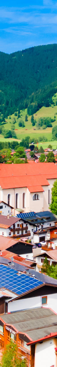 Colorful alpine village with church and mountains