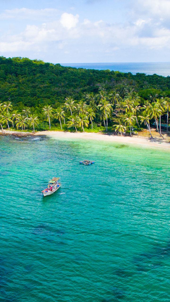 Tropical island with lush greenery and boats