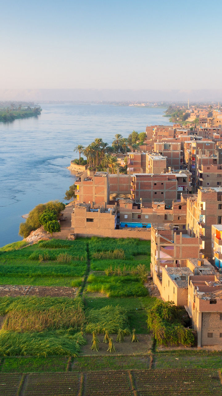 Riverside town and farmland at sunrise