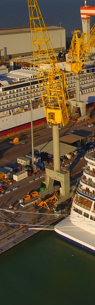 Cruise Ships Docked at Industrial Shipyard at Sunset