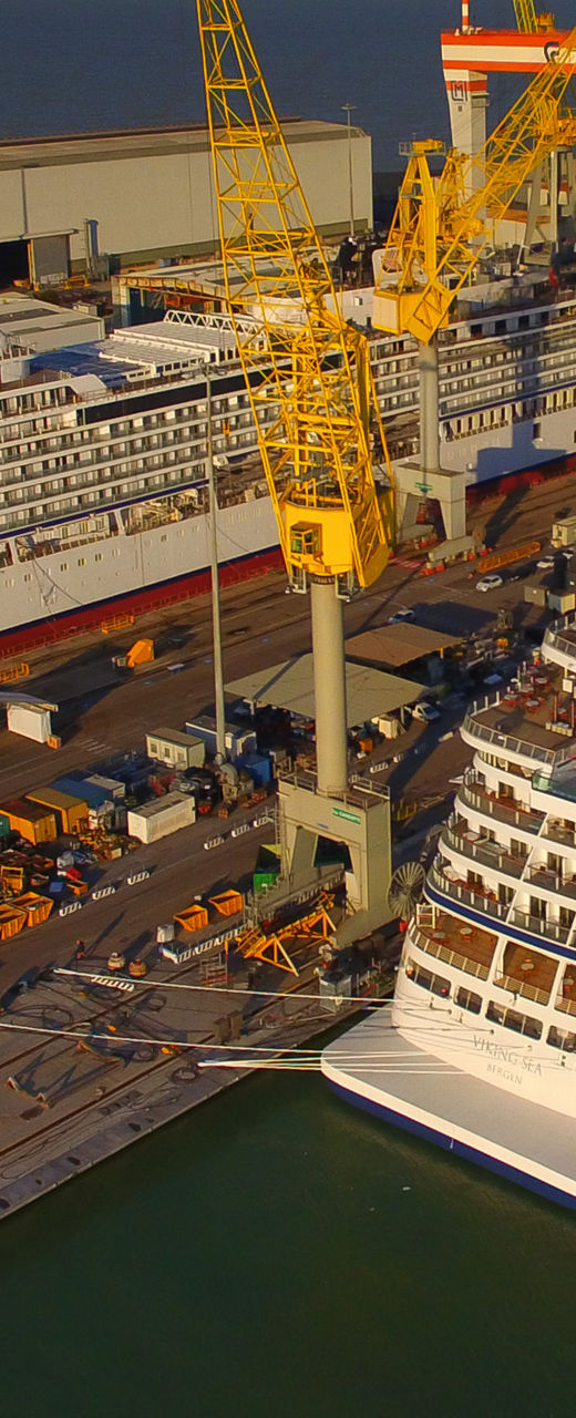 Cruise Ships Docked at Industrial Shipyard at Sunset