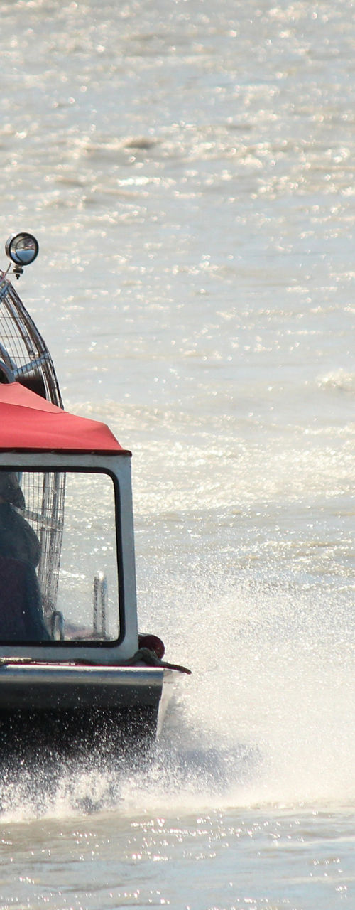 Red airboat speeding on a river