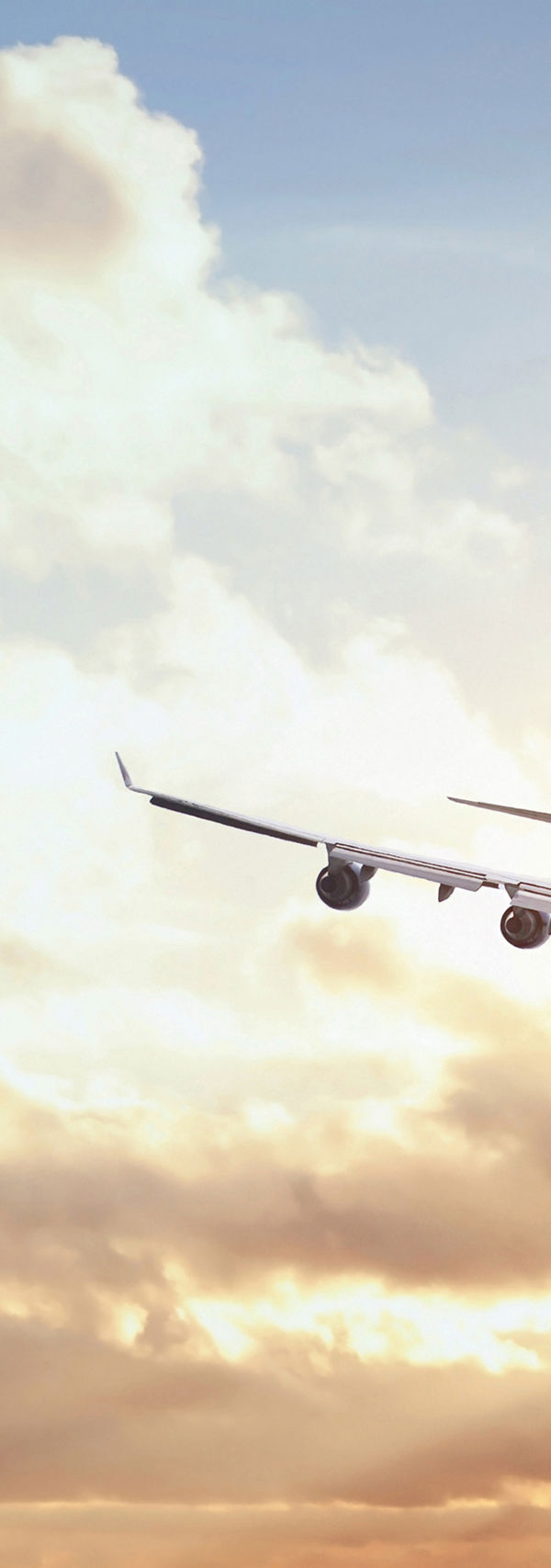 Airplane flying at sunset with clouds