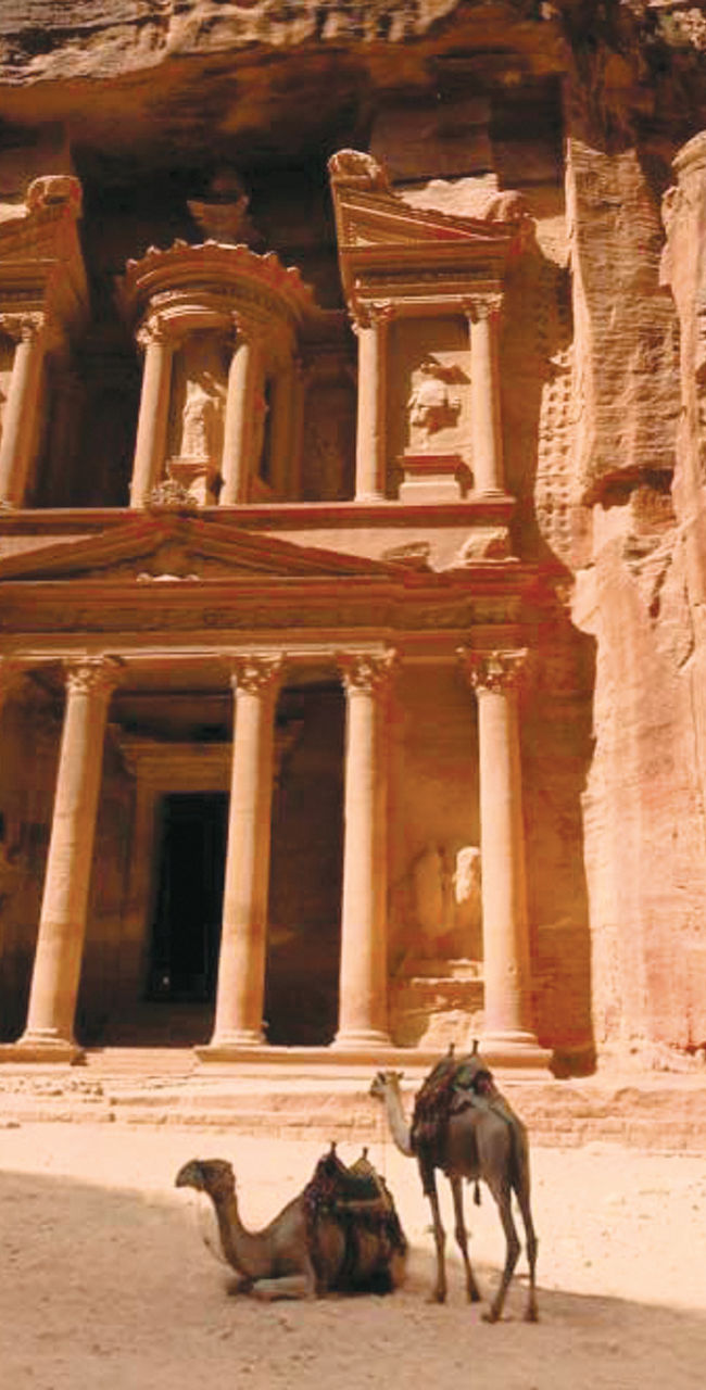 Ancient Petra facade with camels resting