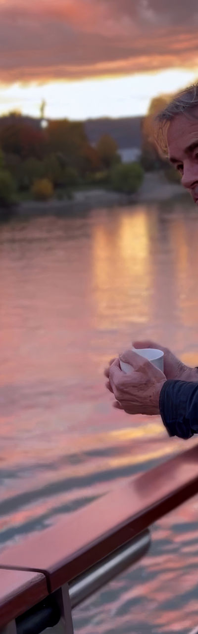 Man admiring sunset over river view