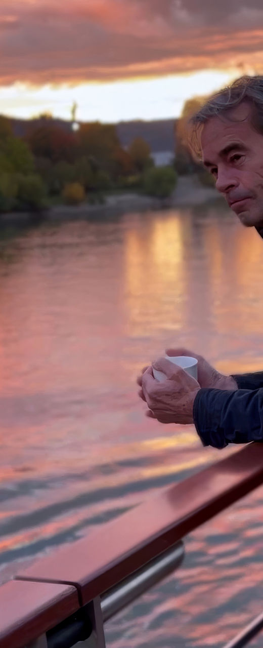 Man admiring sunset over river view