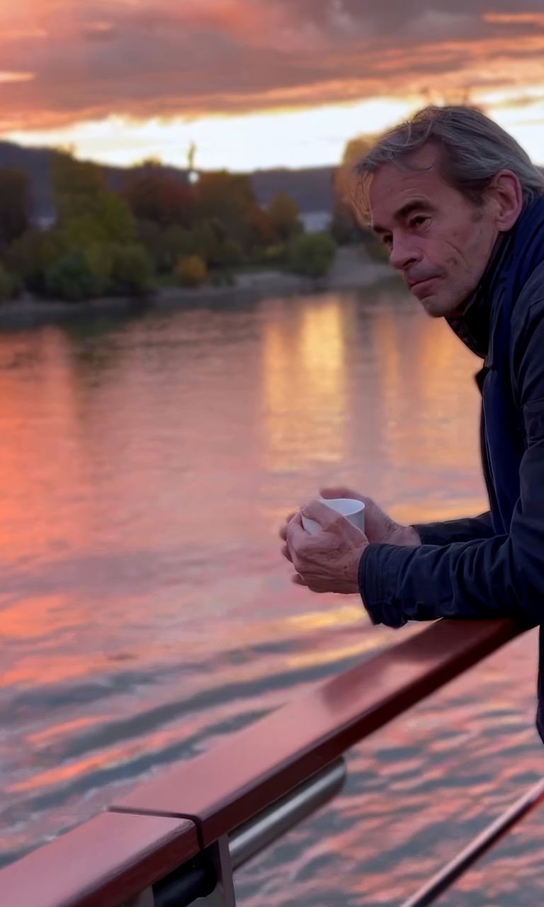 Man admiring sunset over river view