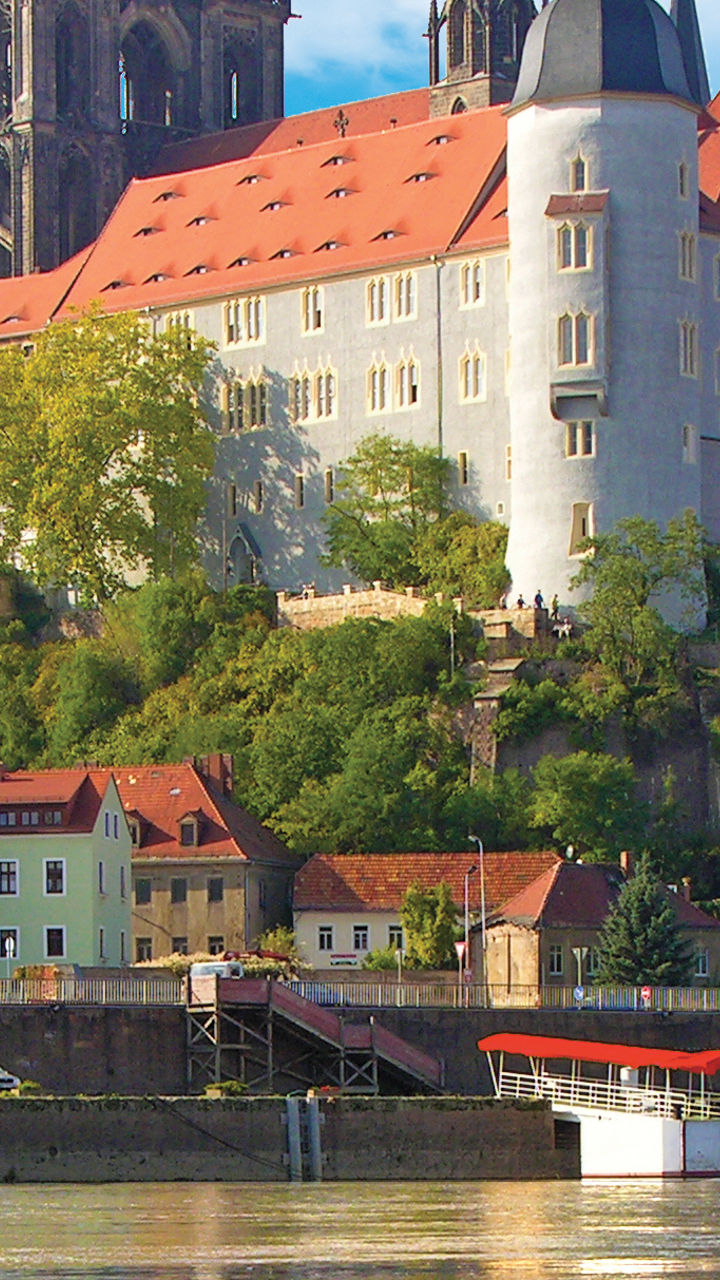 Historic castle by riverside with reflection