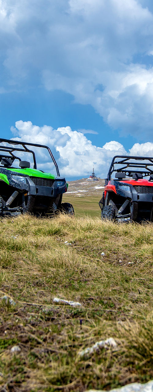 All-terrain vehicles parked on grassy mountain plateau