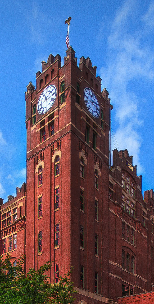 Historic red brick clock tower under blue sky
