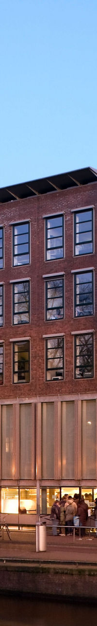Modern building by Amsterdam canal at dusk