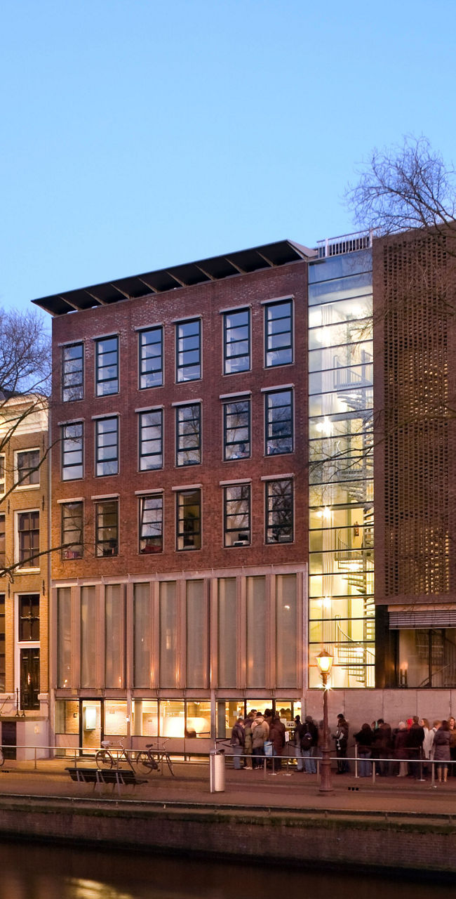 Modern building by Amsterdam canal at dusk