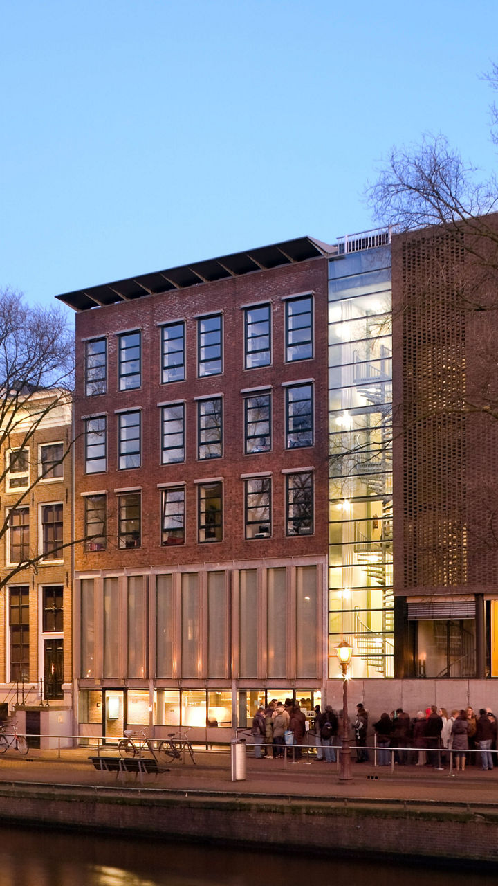 Modern building by Amsterdam canal at dusk
