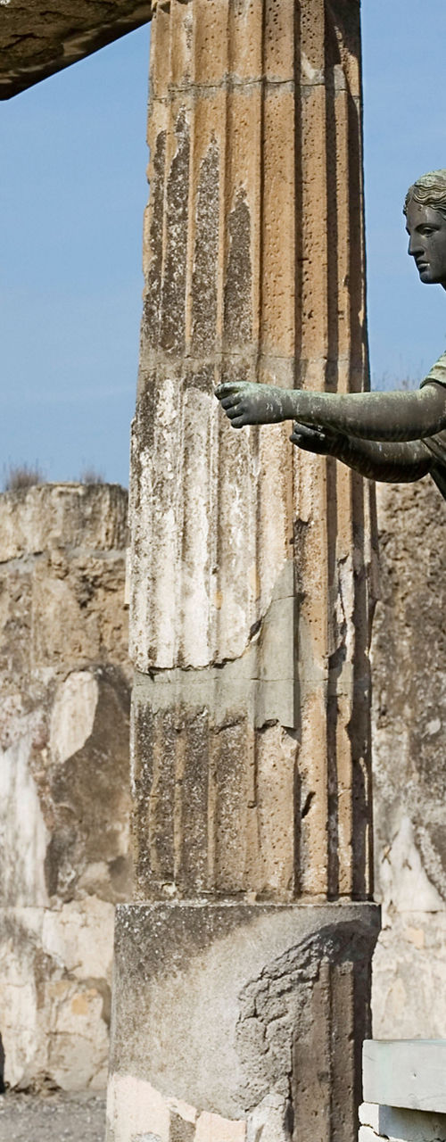 Ancient Roman Ruins with Bronze Statue in Sunlight