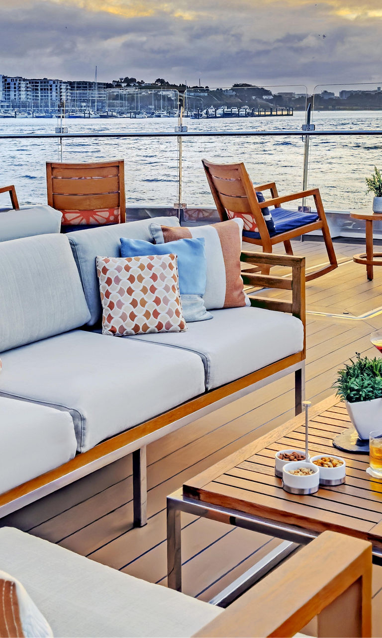 Luxury waterfront terrace at sunset with seating