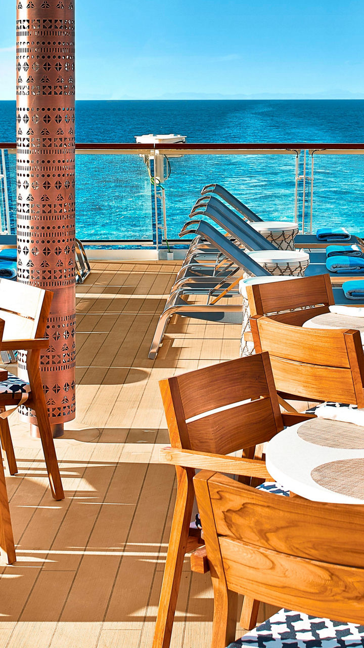 Oceanfront dining area with lounge chairs