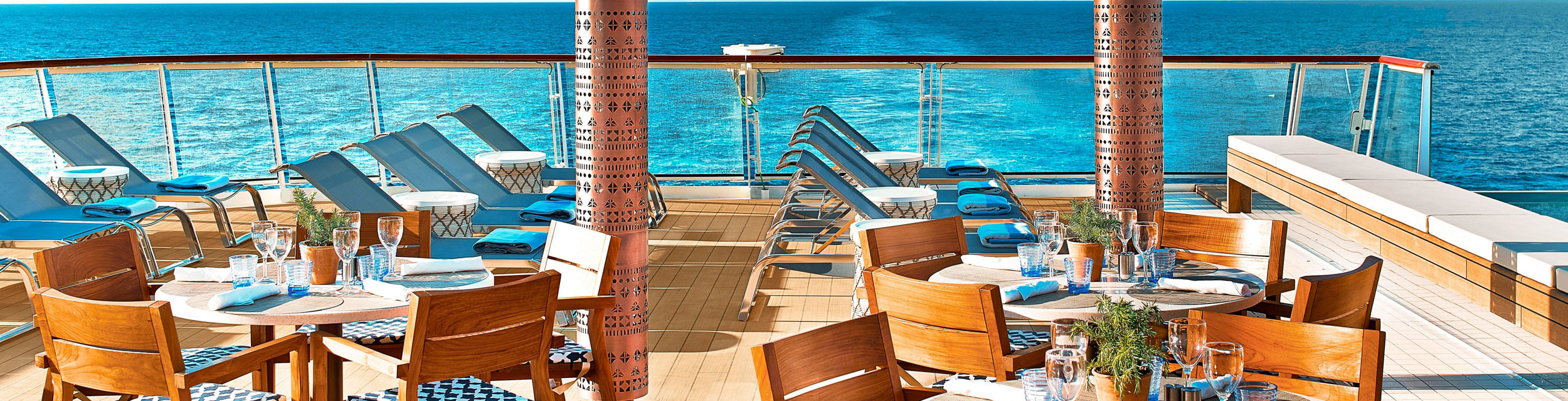 Oceanfront dining area with lounge chairs