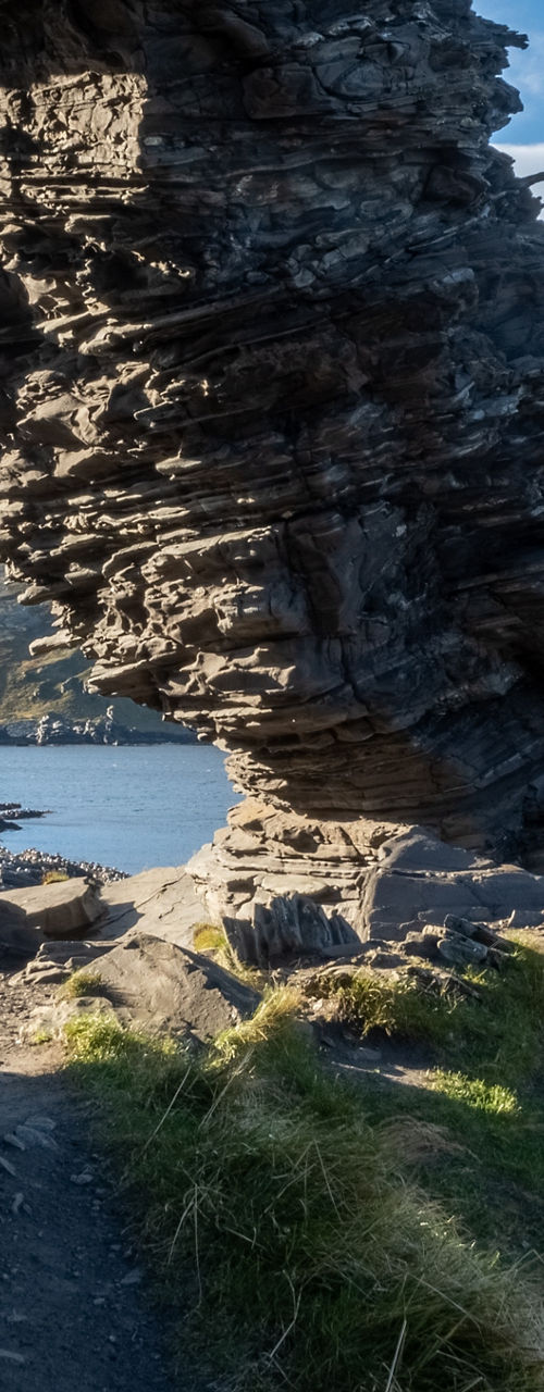 Natural rock arch by coastal landscape