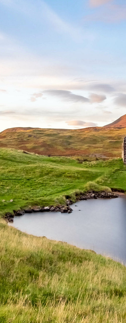 Scenic ruins by a tranquil lake at sunset