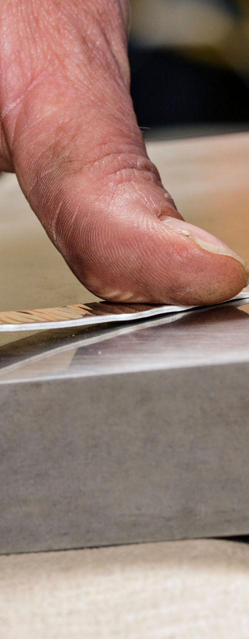 Close-up of hand bending metal strip