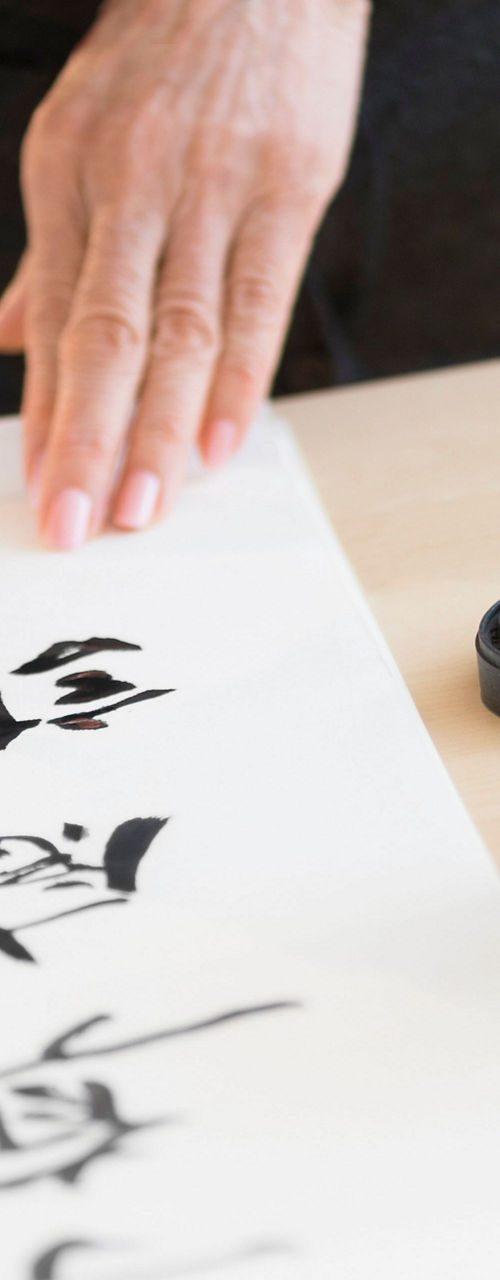 Person practicing traditional calligraphy art
