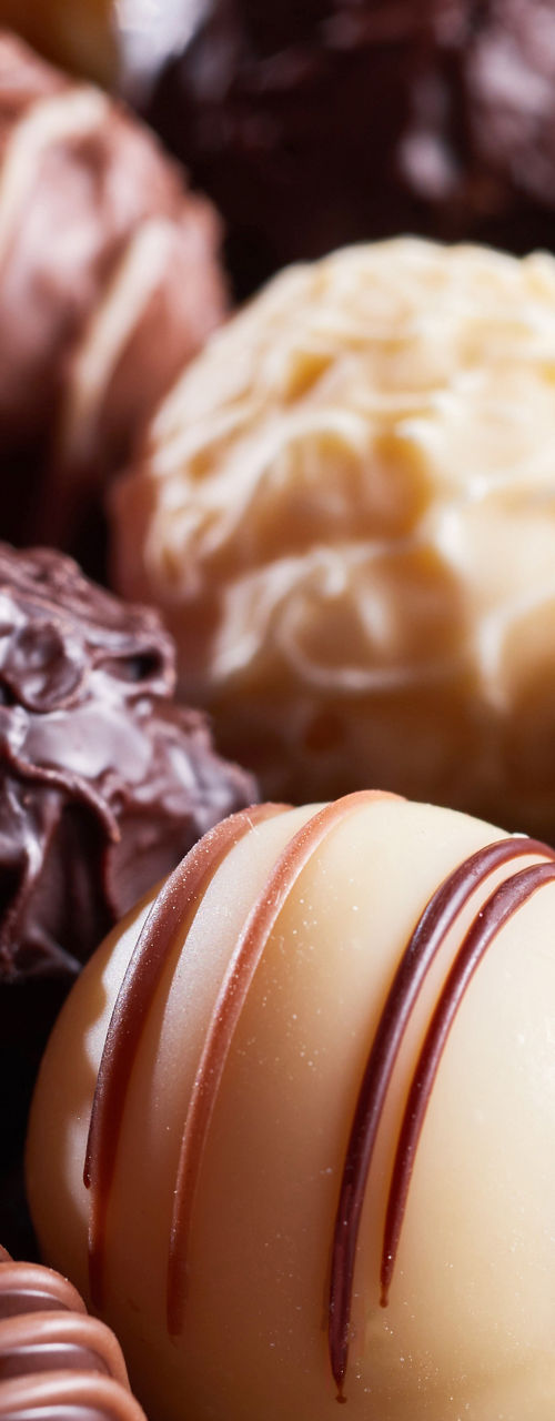 Assorted gourmet chocolate truffles on rustic surface