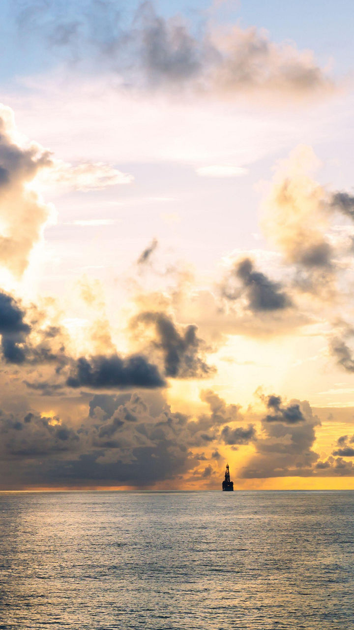 Sailboat at sunset over calm ocean