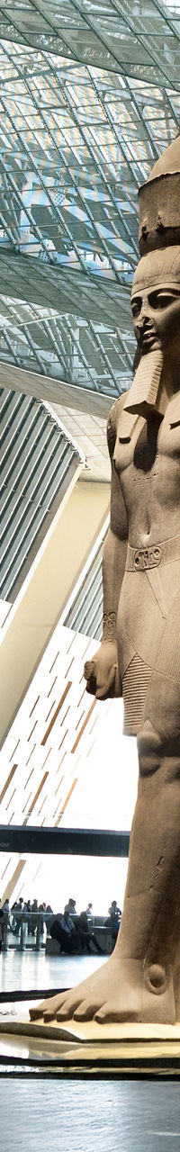 Ancient Egyptian statue in modern museum atrium