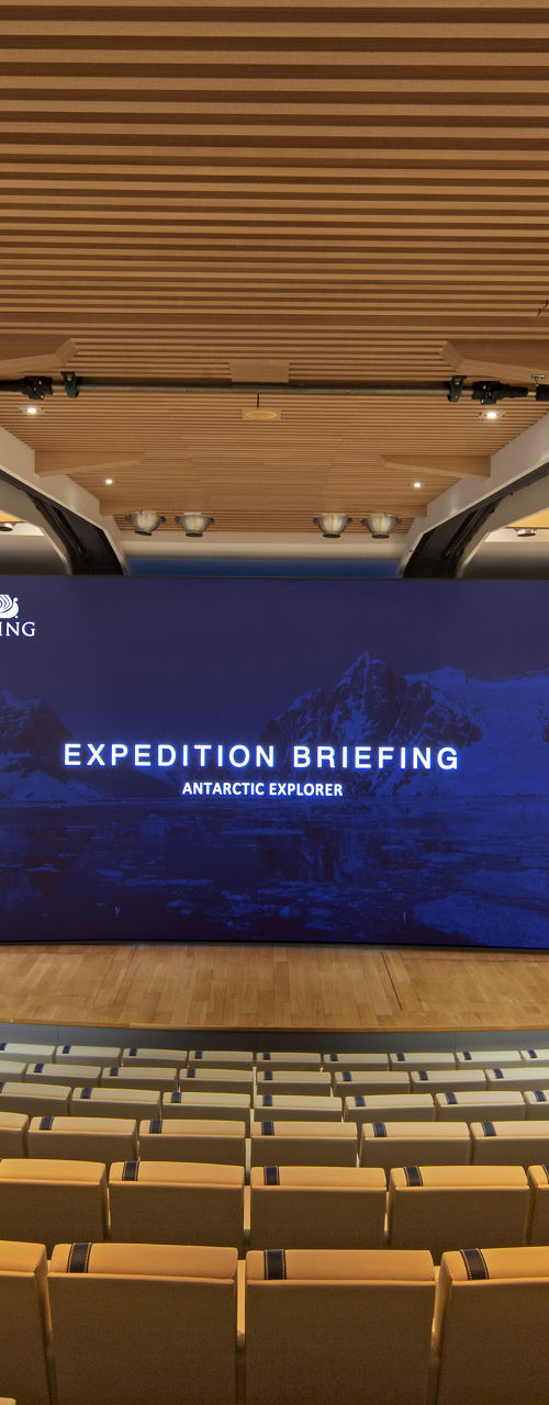 Modern auditorium with expedition briefing screen