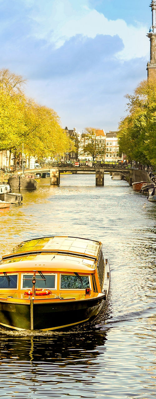 Canal boat cruising in Amsterdam cityscape