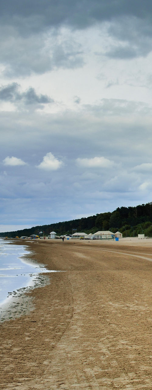 Wide sandy beach with distant seaside buildings