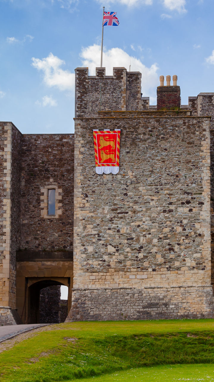 Historic stone castle with flags and blue sky