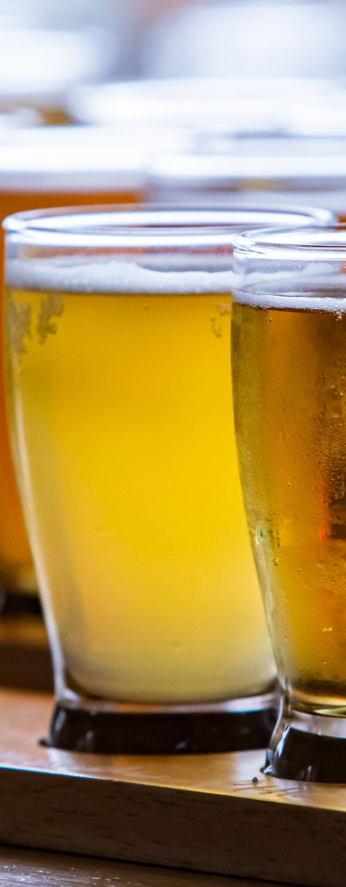 Assorted beer glasses on wooden tray