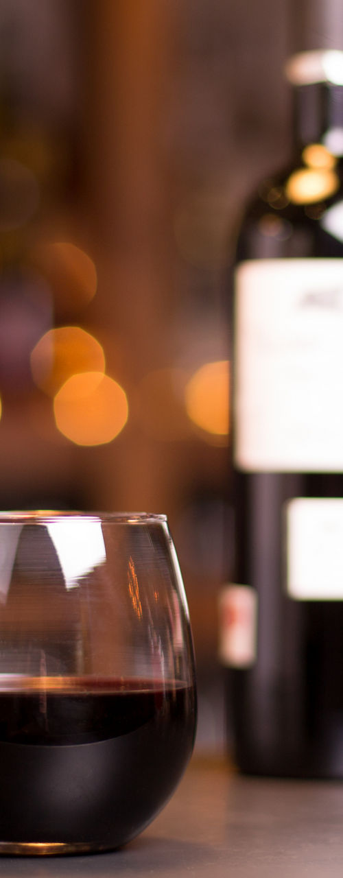 Glass of red wine with bottle in bar