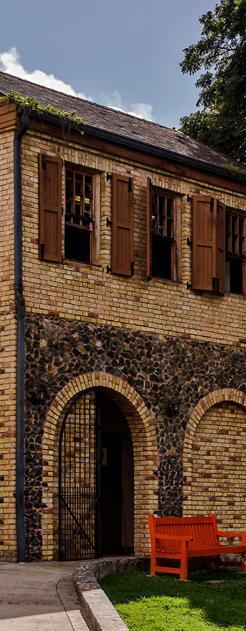 Historic brick building with lush surroundings