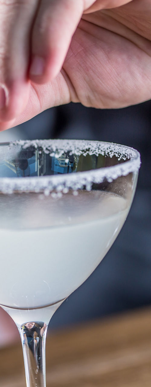 Bartender garnishing lime cocktails on wooden counter