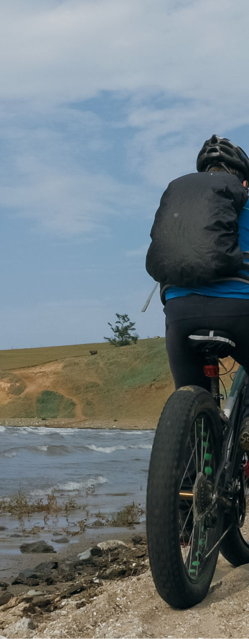 Cyclist riding fat tire bike along sandy beach