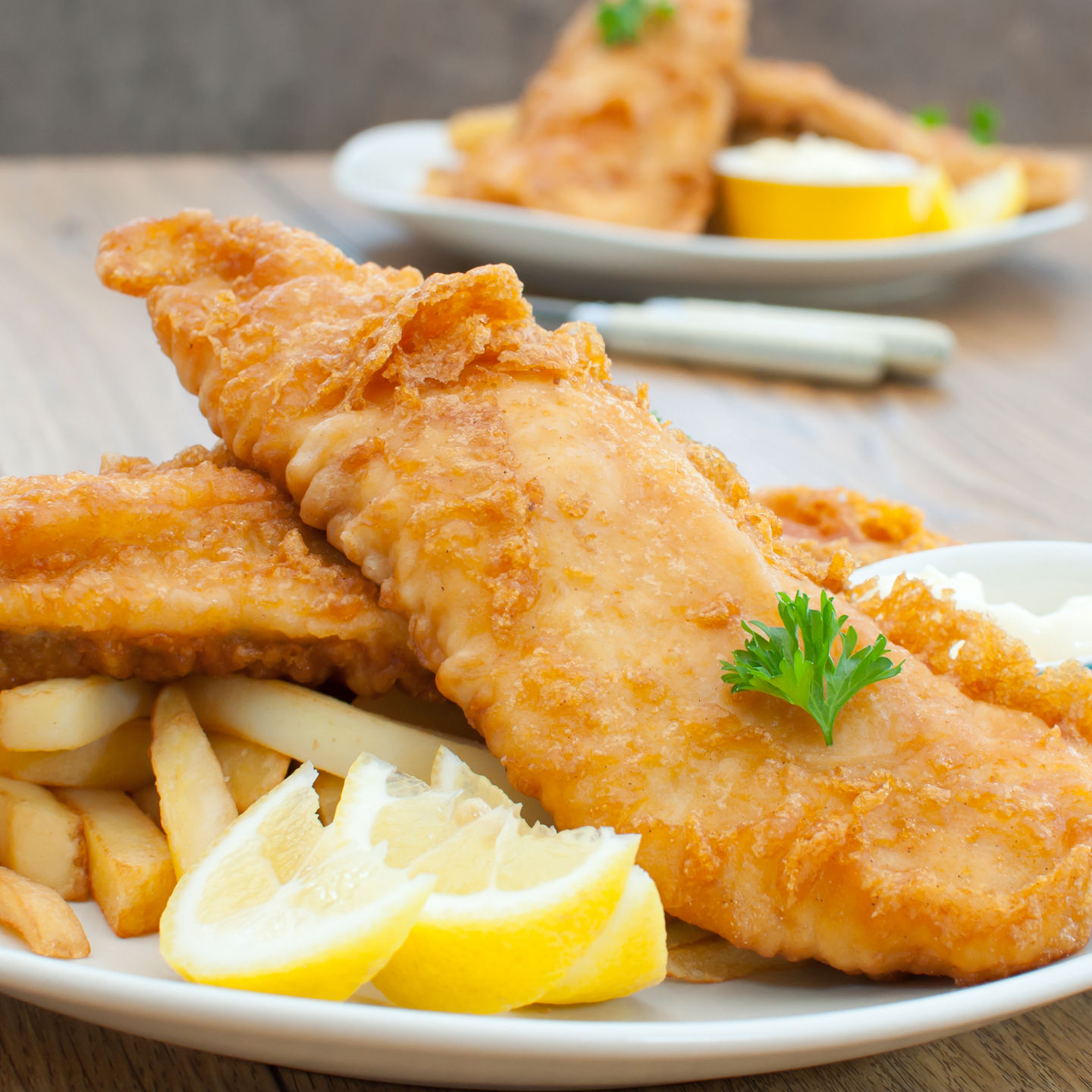 Crispy fish and chips with lemon garnish