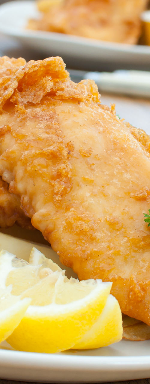 Crispy fish and chips with lemon garnish