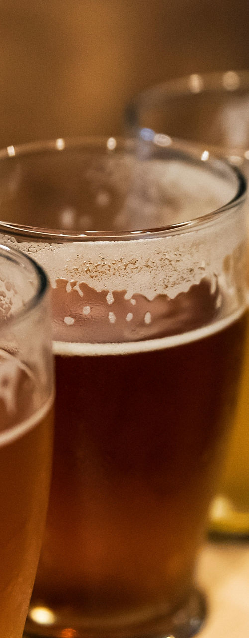 Four craft beer samples on wooden tasting flight