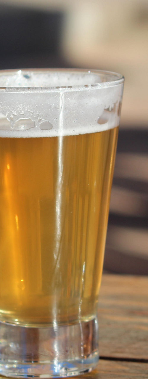 Three glasses of beer on wooden table