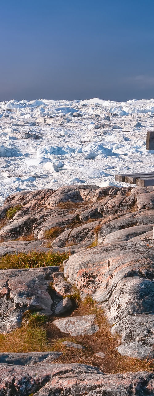 Wooden bench overlooking icy landscape