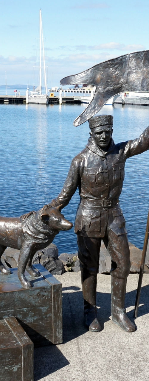 Bronze statue of man and dog by waterfront