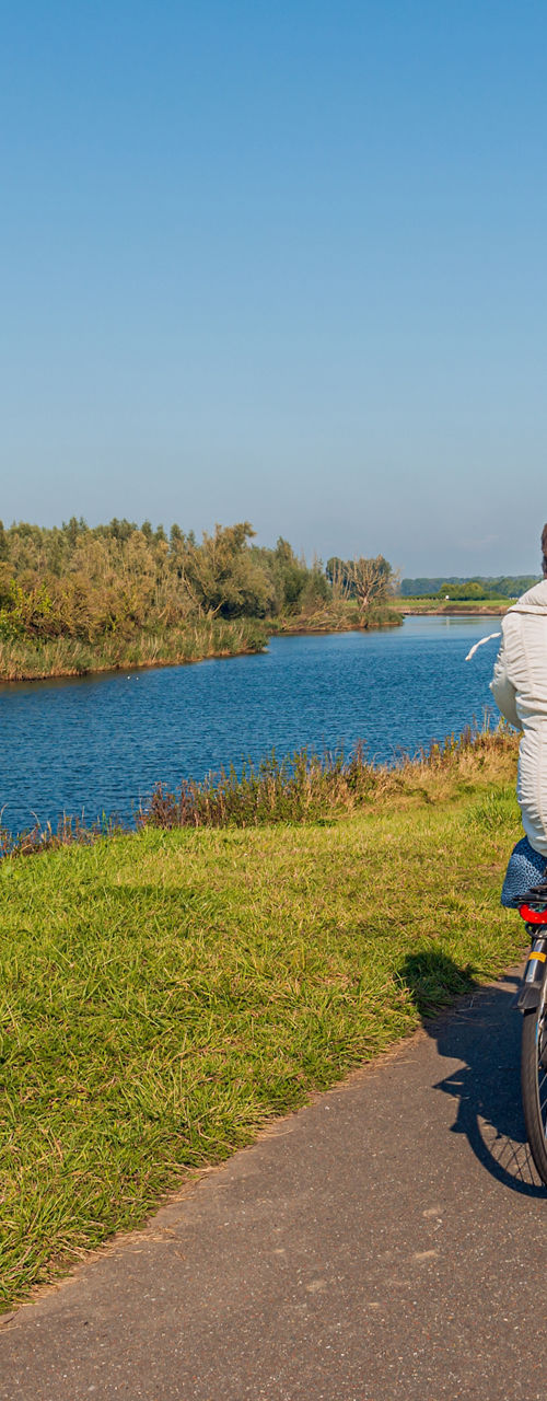 Senior cyclists on rural riverside path