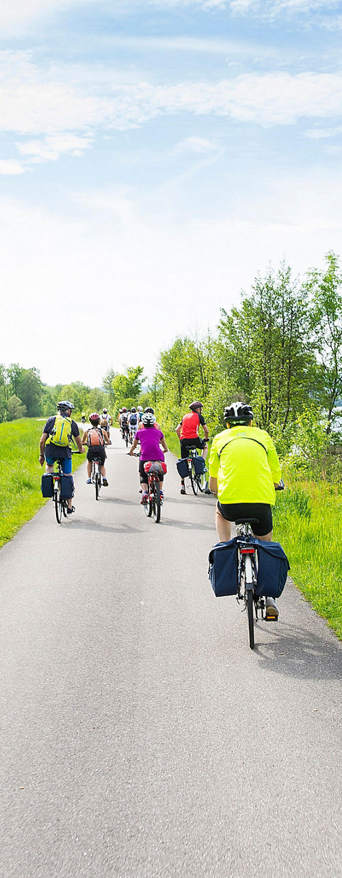 Group cycling on riverside trail