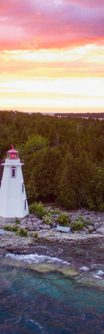 Scenic lighthouse at sunset on rocky island